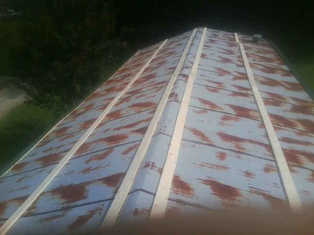 Rusted metal roof panels with new wood purlins before replacement — Storm Damage Roof Repair in Greycliff by Roofing Brothers