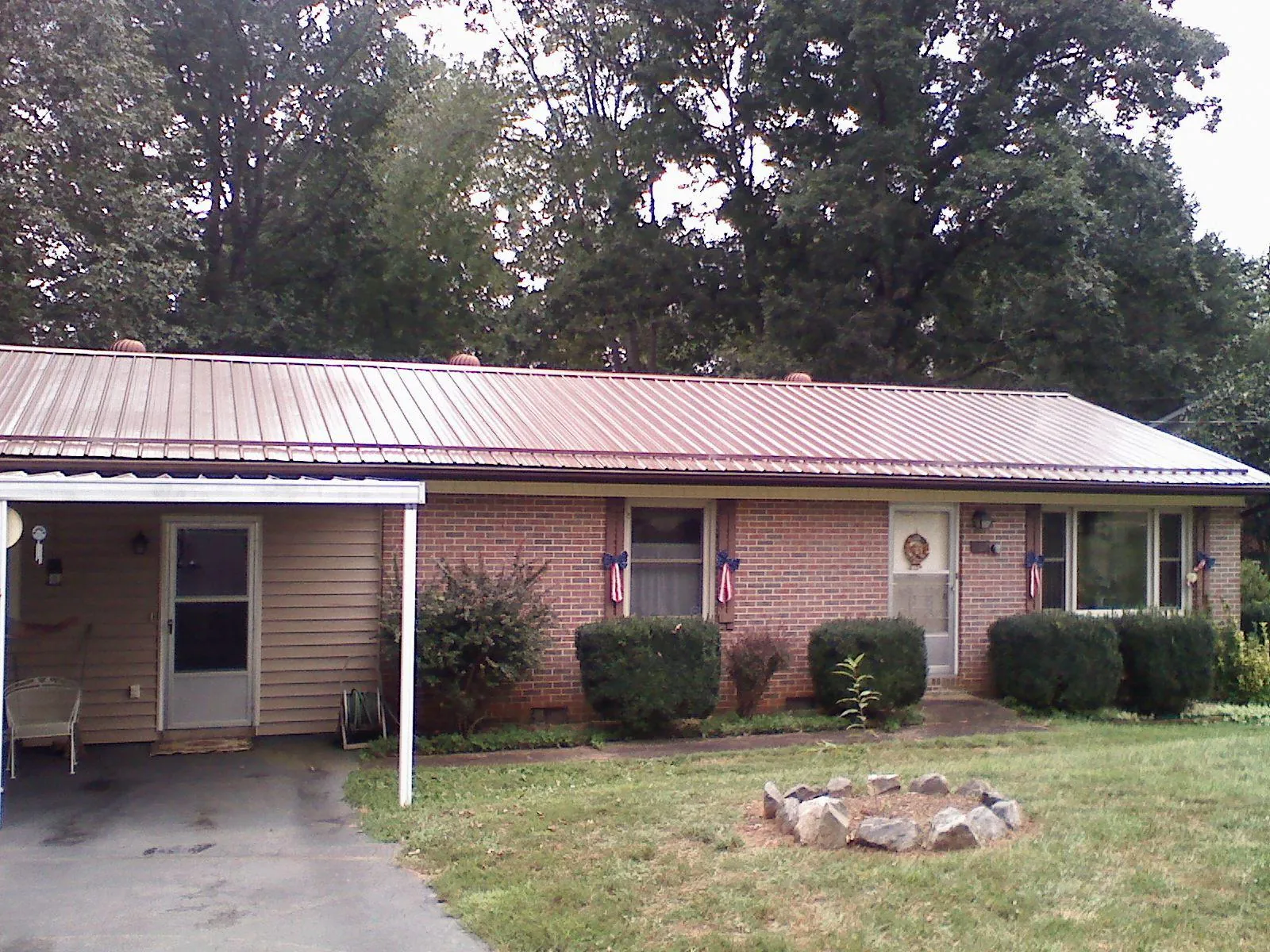 Bronze metal roof and carport on a brick ranch home — Roof Repair work by our crew in Greycliff